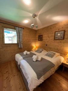 LandryにあるSpacieux 5 pièces sur Peisey-Vallandry - ski aux piedsの木製の壁のベッドルーム1室(大型ベッド1台付)