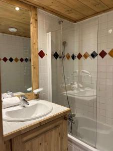 LandryにあるSpacieux 5 pièces sur Peisey-Vallandry - ski aux piedsのシャワー、洗面台、浴槽を備えたバスルーム +10枚の写真