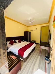 une chambre avec un grand lit recouvert d'une couverture rouge dans l'établissement Hotel Kumbha Heritage, à Kelwāra