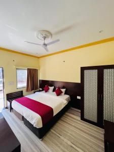 une chambre avec un grand lit avec des oreillers rouges dans l'établissement Hotel Kumbha Heritage, à Kelwāra