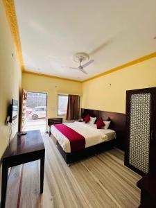 une chambre d'hôtel avec un lit, un bureau et une fenêtre dans l'établissement Hotel Kumbha Heritage, à Kelwāra