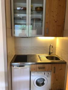 una cocina con lavadora y fregadero en Le Parc03, en Peisey-Nancroix