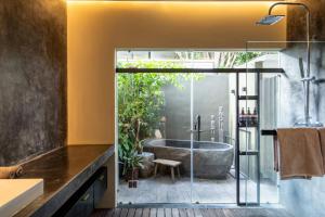 a bathroom with a tub and a sink at Loft 7 Villa by Betterplace in Canggu