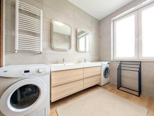 a bathroom with a washing machine and a sink at Trawowa Spacious House by BookingHost in Wrocław