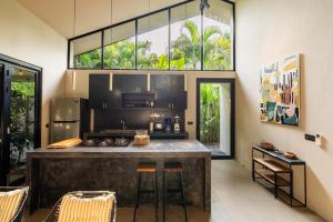 a kitchen with a large island in a room with windows at Loft 7 Villa by Betterplace in Canggu