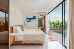 a bedroom with a bed and a view of a pool at Nidya Villa Canggu in Canggu