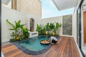 a man in a pool with a bowl of food at Nidya Villa Canggu in Canggu +18 photos