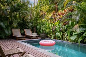 a pool with two chairs and a frisbee in a garden at Loft 7 Villa by Betterplace in Canggu +30 photos