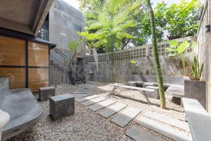 un patio con bancos y una valla con árboles en Manta Living Bandung RedPartner, en Bandung
