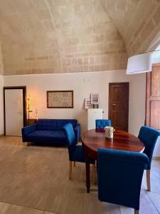 a living room with a table and blue chairs at Le Dimore al Castello in Massafra