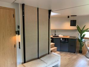 a living room with a couch and a kitchen at The Nutshell met hottub en sauna | 2 personen in Neede