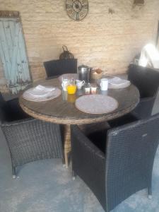 a wooden table with chairs and a clock on the wall at La Cour in Villefagnan +11 photos