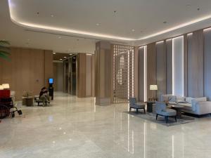 a lobby with blue chairs and a person sitting at Apt Minimalis Tokyo Riverside at PIK2 in Muara
