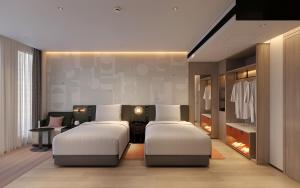 a bedroom with two beds and a dressing room at EVEN Hotel Shanghai Jinqiao by IHG in Shanghai
