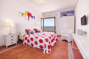 a bedroom with a bed with a polka dot spread at Escape to Luxury: Rent Mallorca Villa 1452 in Cala Vinyes +12 photos