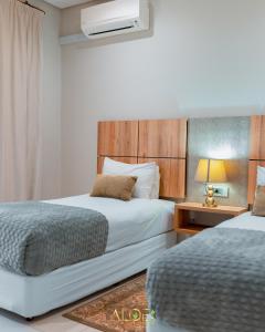 a bedroom with two beds and a lamp on a table at Aloe Lifestyle Hotel in Eshowe +38 photos