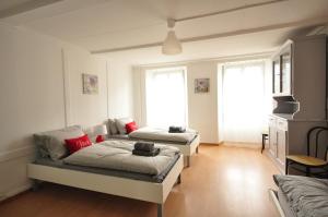 two beds in a room with two windows at Townhouse II Sleeps 12 guests Central in Interlaken