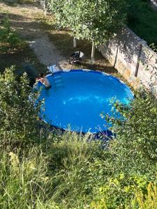 a blue swimming pool with two chairs in a yard at Hovek Guest House in Dilijan