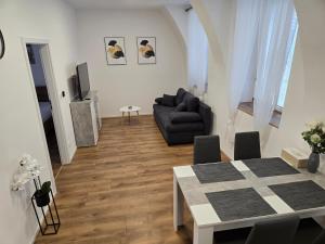 a living room with a black couch and a table at Apartmán Anežka -1- in Jičín