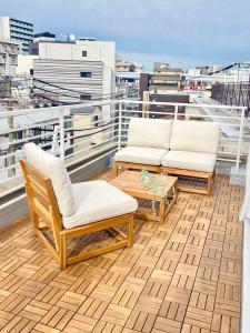 two chairs and a coffee table on a balcony at Koubanoyado in Tokyo