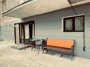 an orange bench sitting next to a table with chairs at House Lia Apartment Likani in Borjomi