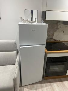 a white refrigerator in a kitchen next to a couch at South Blue Apartment in Trani +4 photos