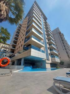 a large building with a pool in front of it at Tulip Creek Hotel Apartments in Dubai