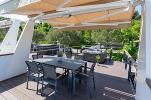 patio con tavolo e sedie sotto ombrellone di Floating Seahouse Ocean Beauty a Portoroz
