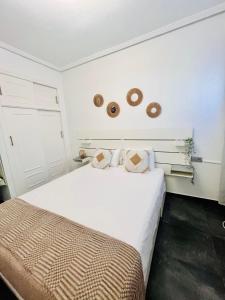 Un dormitorio con una gran cama blanca y dos donas en la pared. en Casa La Paz, en Torrevieja 67 fotos más