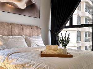 a bedroom with a white bed with a window at Danga Bay Seaview Escape 3BR 8pax Balcony by Our Stay in Johor Bahru +62 photos