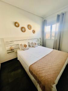 Un dormitorio con una cama grande con dos almohadas. en Casa La Paz, en Torrevieja