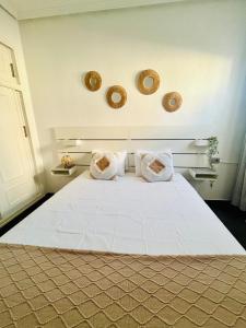 Un dormitorio con una gran cama blanca con dos almohadas. en Casa La Paz, en Torrevieja