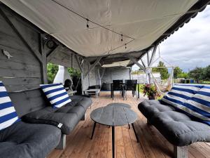 d'une terrasse couverte avec des canapés, une table et une table. dans l'établissement Sarbi Mare, à Sarbinowo