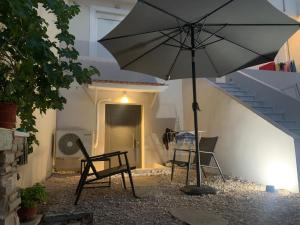 a patio with a table and chairs and an umbrella at Komi Beach Apartment in Kómi