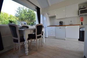 a kitchen with a table and chairs and a window at Beach Cottage Zandvoort in Zandvoort