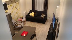 a living room with a black couch and a table at Sohosuite in Lille