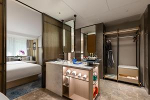 上海上海虹桥荷逸唐酒店北新泾地铁站Shanghai Hongqiao Heyitang Hotel Beixinjing Subway Station Branch的一间带床的卧室和一间带水槽的浴室