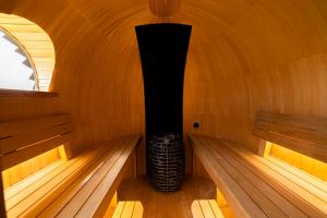 a small sauna with a woodburning stove in it at Nest - luxe wellness met privé sauna in Friesland in Luxwoude