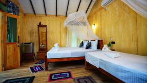 una camera con due letti e una rete di Akash Treehouse a Sigiriya Altre 37 foto