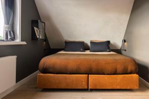 a bedroom with a bed with a brown foot board at Nest - luxe wellness met privé sauna in Friesland in Luxwoude
