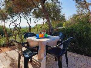 a table with chairs and a plate of food on it at Villette Vista Mare in Rena Majore +5 photos
