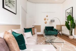 a living room with a white couch and a green chair at West Kensigton Superb Apartments! in London +48 photos