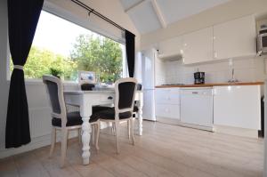 a kitchen with a table with chairs and a window at Beach Cottage Zandvoort in Zandvoort