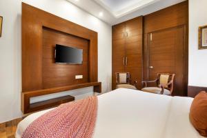a bedroom with a bed and a flat screen tv at The Crest on Library Road in Mussoorie