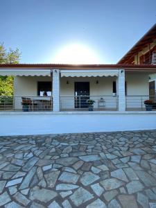 a house with a stone patio in front of it at Mitsis Home in Kypséli