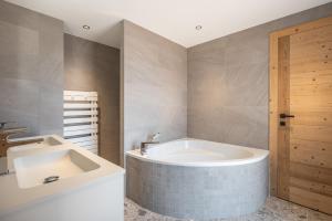 un bagno con vasca e lavandino di Apartment La Chouette Les Belleville - by EMERALD STAY a Levassaix