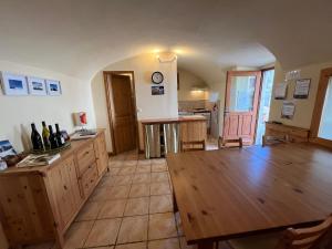 a large room with a wooden table and a kitchen at La compagnie du bourg in Le Châtelard +9 photos