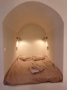 a bed in a small room with an arched ceiling at Studio Méditerranéen Climatisé in Périgueux