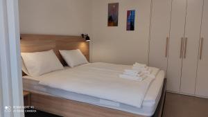 a bedroom with a bed with white sheets and pillows at MAKS 2 Osijek Center, self check in in Osijek