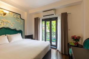 a bedroom with a bed and a sliding glass door at Hanoi House Hotel & Travel in Hanoi +72 photos